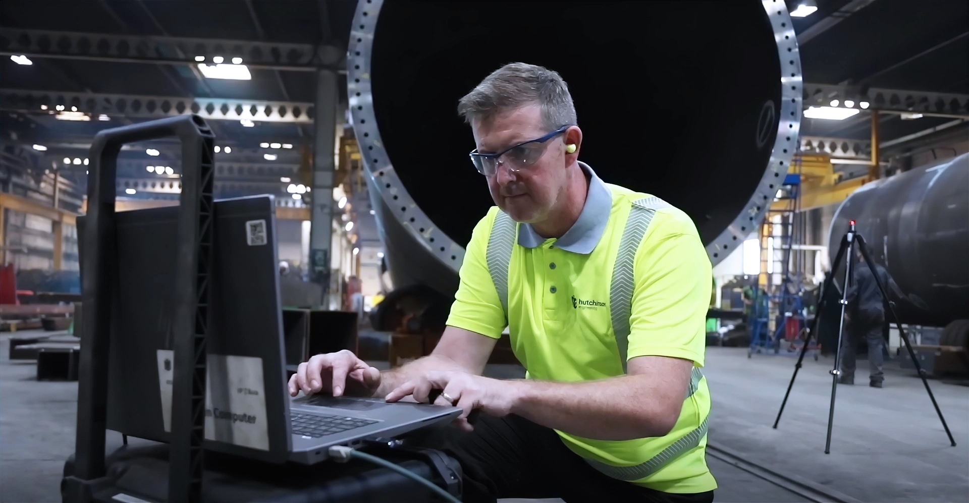 Someone working on a laptop in a factory
