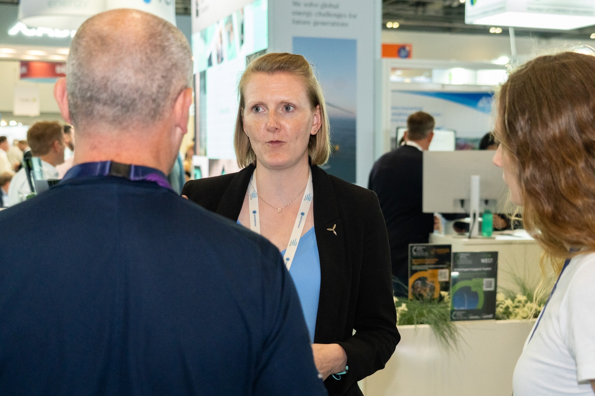 Three people talking to each other at a conference